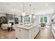 Modern open-concept kitchen with large island, pendant lights, and seamless flow to living and dining areas at 12594 Pasco St, Fishers, IN 46038