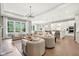 Bright, open-concept living room flows into kitchen, featuring hardwood floors and large windows at 12594 Pasco St, Fishers, IN 46038