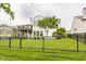 Well-maintained backyard featuring an iron fence, lush green grass, a cozy deck, and a tree at 13091 Duval Dr, Fishers, IN 46037