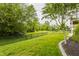 A large, grassy backyard features an iron fence and mature landscaping at 13091 Duval Dr, Fishers, IN 46037