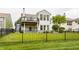 Beautiful backyard featuring an iron fence, lush green grass, a cozy deck, and mature trees at 13091 Duval Dr, Fishers, IN 46037