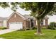 Beautiful brick home with attached garage, lush front yard and mature trees creating an inviting facade at 13091 Duval Dr, Fishers, IN 46037