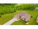 Aerial view of a well-kept brick home with lush green lawns, mature trees, and an outdoor storage shed at 1324 N Stewart Rd, Anderson, IN 46012
