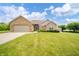 Attractive brick home with a two-car garage, surrounded by green lawns and well-maintained landscaping at 1324 N Stewart Rd, Anderson, IN 46012