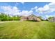 Lovely brick home with a two-car garage, complemented by a spacious lawn and charming landscaping details at 1324 N Stewart Rd, Anderson, IN 46012
