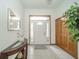Inviting foyer featuring tile flooring, a decorative table with accessories, and a bright entryway at 1324 N Stewart Rd, Anderson, IN 46012