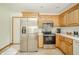 Updated kitchen featuring stainless steel appliances, light countertops, and warm wooden cabinetry at 1324 N Stewart Rd, Anderson, IN 46012