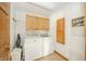 Functional laundry room equipped with a washer, dryer, and storage cabinets at 1324 N Stewart Rd, Anderson, IN 46012