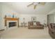 Comfortable living room with a fireplace, neutral carpet, and modern ceiling fan at 1324 N Stewart Rd, Anderson, IN 46012