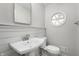 Bathroom with wainscoting features a pedestal sink, round window, and modern fixtures at 1325 Alimingo Dr, Indianapolis, IN 46260