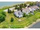 Aerial view of the property, showcasing a fenced backyard, covered patio, and a tranquil neighborhood pond at 1412 Huntzinger Blvd, Pendleton, IN 46064