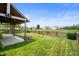 Well-maintained backyard with a covered patio, bordered by a serene pond and lush landscaping at 1412 Huntzinger Blvd, Pendleton, IN 46064