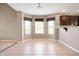 Dining area featuring tile flooring, dark wood cabinetry, granite countertop bar, and three large windows at 1412 Huntzinger Blvd, Pendleton, IN 46064