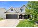 Charming two-story home with a well-manicured lawn, dark garage, and welcoming front porch at 1412 Huntzinger Blvd, Pendleton, IN 46064