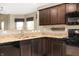 Modern kitchen showcasing granite countertops, sleek black appliances, and wood cabinetry for ample storage at 1412 Huntzinger Blvd, Pendleton, IN 46064