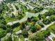 Community aerial view highlighting a house outlined in red, near a scenic pond amidst a neighborhood at 1506 Bowman Dr, Greenfield, IN 46140