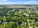 Community aerial view featuring a tranquil pond, lush greenery, and a sprawling neighborhood with a red roof marker at 1506 Bowman Dr, Greenfield, IN 46140