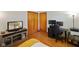 Functional bedroom/office with hardwood floors, television, desk and office equipment at 1506 Bowman Dr, Greenfield, IN 46140