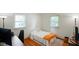 Small bedroom with hardwood floors, bright windows, and a comfy bed with orange accent blanket at 1506 Bowman Dr, Greenfield, IN 46140