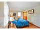 Sunlit bedroom with wood floors, and a comfortable queen-size bed with a cozy blue comforter at 1506 Bowman Dr, Greenfield, IN 46140