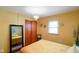 Sunny bedroom with bright yellow walls and hardwood floors with closet, large mirror and window at 1506 Bowman Dr, Greenfield, IN 46140