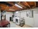 Basement laundry room featuring white washer and dryer, utility sink, and exposed wooden beams at 1506 Bowman Dr, Greenfield, IN 46140
