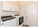 Bright laundry room featuring modern washer and dryer with overhead cabinets for storage at 15097 Thoroughbred Dr, Fishers, IN 46040