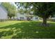 A spacious backyard featuring a well-maintained lawn, mature trees, and a wooden deck perfect for outdoor enjoyment at 17916 Racebrook Ct, Noblesville, IN 46062