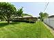 Side view of a well-maintained brick house with green lawn, mature tree, and fenced backyard at 1910 Ivy Dr, Anderson, IN 46011