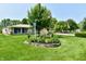 A view of the well-manicured front yard with flower beds and a charming garden at 1910 Ivy Dr, Anderson, IN 46011