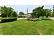 Well-maintained front yard with lush green lawn, mature trees, and colorful flowerbeds enhancing curb appeal at 1910 Ivy Dr, Anderson, IN 46011