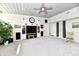 Open living room with large entertainment center, ceiling fan, and neutral carpet at 1910 Ivy Dr, Anderson, IN 46011
