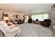 Spacious living room featuring plush carpeting, neutral tones, and ample seating for entertaining guests at 1910 Ivy Dr, Anderson, IN 46011