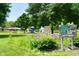 Redwood Park features a playground, benches, flowers, and mature trees in the town of Edgewood at 1910 Ivy Dr, Anderson, IN 46011
