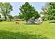 A community playground with swings, a slide, and a colorful climbing structure surrounded by green grass at 1910 Ivy Dr, Anderson, IN 46011