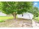 A lush backyard with a large tree shading a weathered white garage at 2009 S L St, Elwood, IN 46036