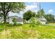 The backyard showcases a lush lawn and a white garage with mature trees at 2009 S L St, Elwood, IN 46036