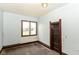 Empty bedroom with peeling paint, wood trim, and window with natural light at 2009 S L St, Elwood, IN 46036