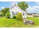 Charming white bungalow with a quaint front yard and concrete steps to the front door at 2009 S L St, Elwood, IN 46036