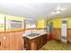 Outdated kitchen featuring a stainless steel sink, yellow walls and flooring, and an old window AC unit at 2009 S L St, Elwood, IN 46036