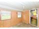 A room with wood paneling and two windows, with a view into the kitchen at 2009 S L St, Elwood, IN 46036