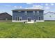 Back of a blue two-story house with green lawn and a concrete patio featuring chairs and a grill at , Westfield, IN 46074