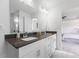 A bathroom featuring double sinks, a black countertop and white cabinets at , Westfield, IN 46074
