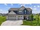 Stunning two-story home featuring a three-car garage and a cozy front porch with manicured green lawn at , Westfield, IN 46074
