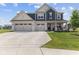 Charming two-story home featuring a three-car garage, a manicured lawn and a welcoming front porch with rocking chairs at , Westfield, IN 46074