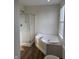 Well-lit bathroom with a glass-enclosed shower and a separate bathtub next to a window at 2540 Lullwater Ln, Indianapolis, IN 46229