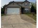 Traditional two-story home with a two-car garage, neutral siding, and a well-maintained front yard at 2540 Lullwater Ln, Indianapolis, IN 46229