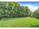 Expansive, well-maintained backyard with a dark metal fence surrounded by mature trees and greenery at 2614 Daylily Ct, Westfield, IN 46074