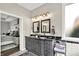 Stylish bathroom featuring double sinks, ample vanity storage, modern lighting, and a glimpse into an adjacent bedroom at 2614 Daylily Ct, Westfield, IN 46074