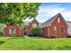 Beautiful two-story red brick home with a manicured lawn, walkway, and lush landscaping at 2614 Daylily Ct, Westfield, IN 46074